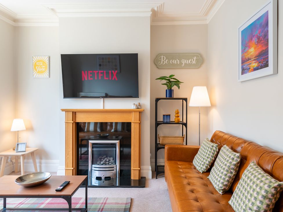 A living room with a television mounted above a fireplace at 18 Mayville Avenue Scarborough