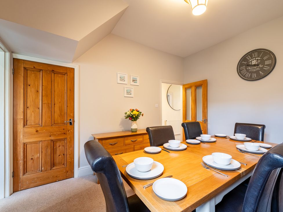 A dining room with a table set for meals at 18 Mayville Avenue Scarborough