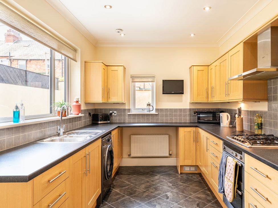 A kitchen with wooden cabinets and appliances at 18 Mayville Avenue, Scarborough