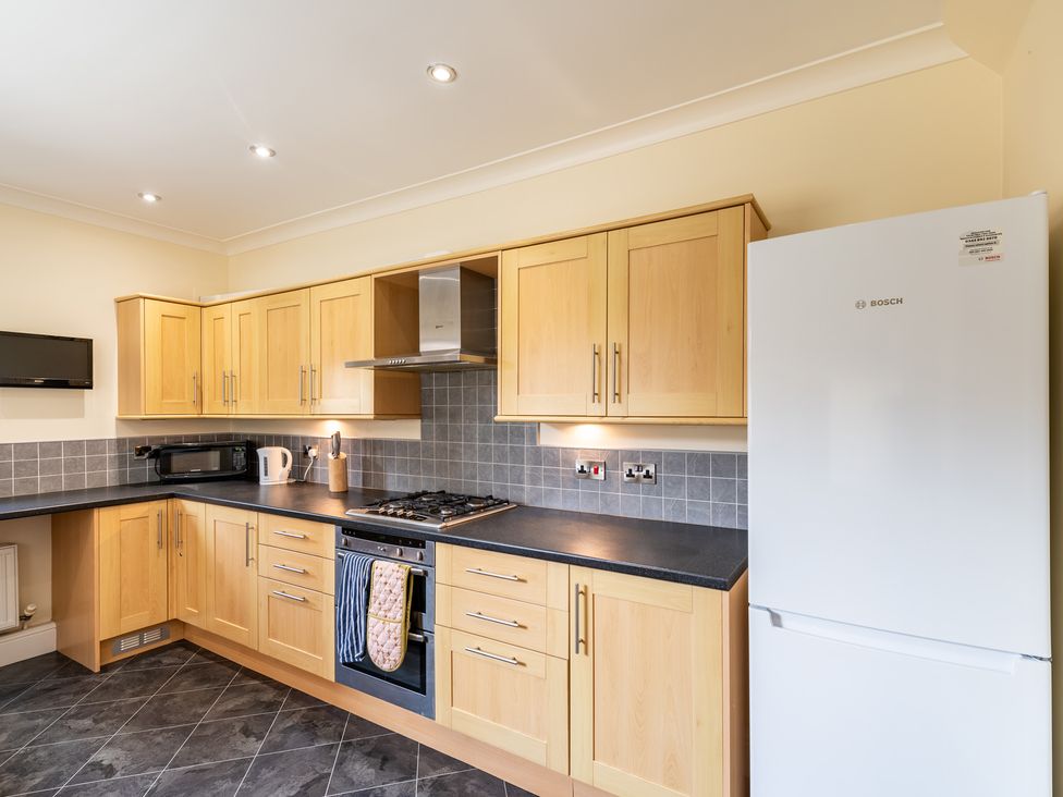 A kitchen with cabinets, stove, microwave, and refrigerator at 18 Mayville Avenue in Scarborough