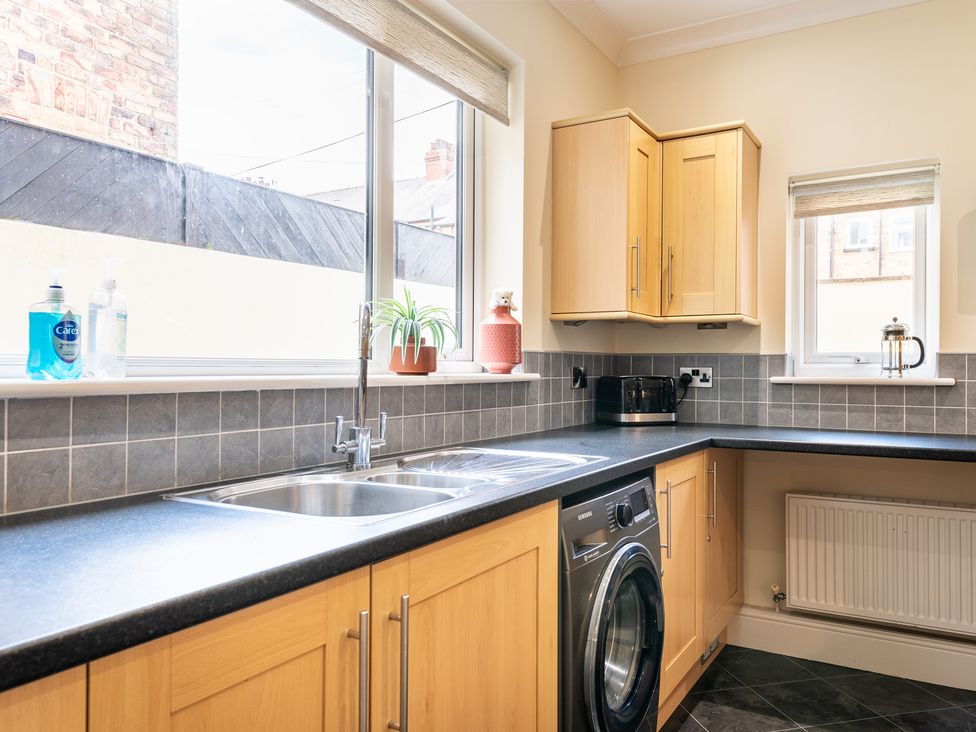 A kitchen with sink and washing machine at 18 Mayville Avenue Scarborough