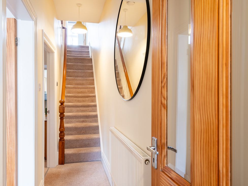 A hallway with a mirror and staircase at 18 Mayville Avenue Scarborough