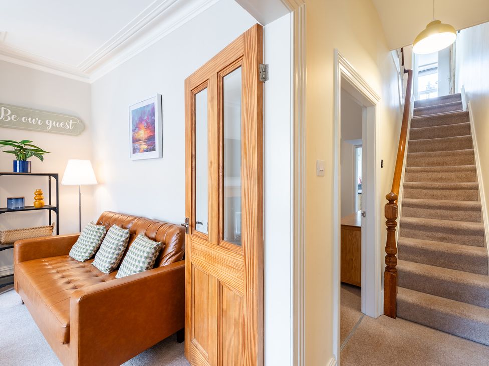 A living room with a sofa and staircase at 18 Mayville Avenue Scarborough