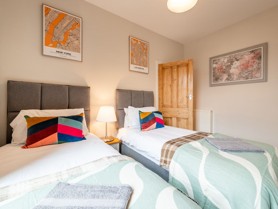 Two single beds with colorful pillows in a bedroom at 18 Mayville Avenue Scarborough