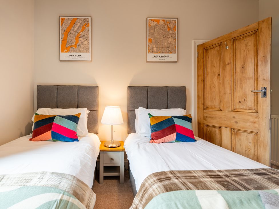 A bedroom with two single beds and a bedside table at 18 Mayville Avenue in Scarborough