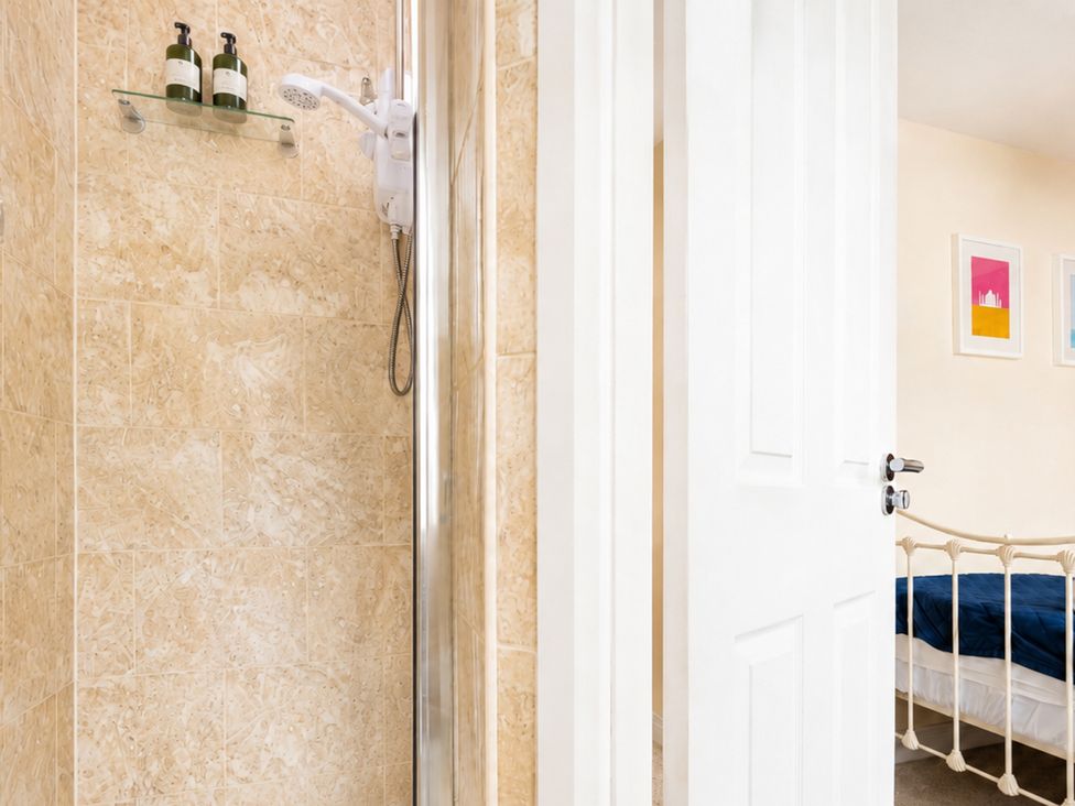 A shower with soap dispenser and a door leading to a bedroom at 125 Columbus Ravine in Scarborough