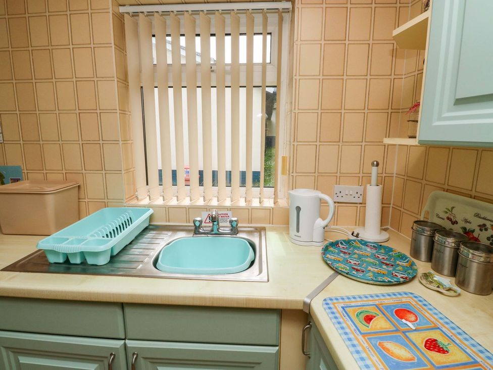 A kitchen with a sink, kettle and storage containers at Cottage 28 in Brixham