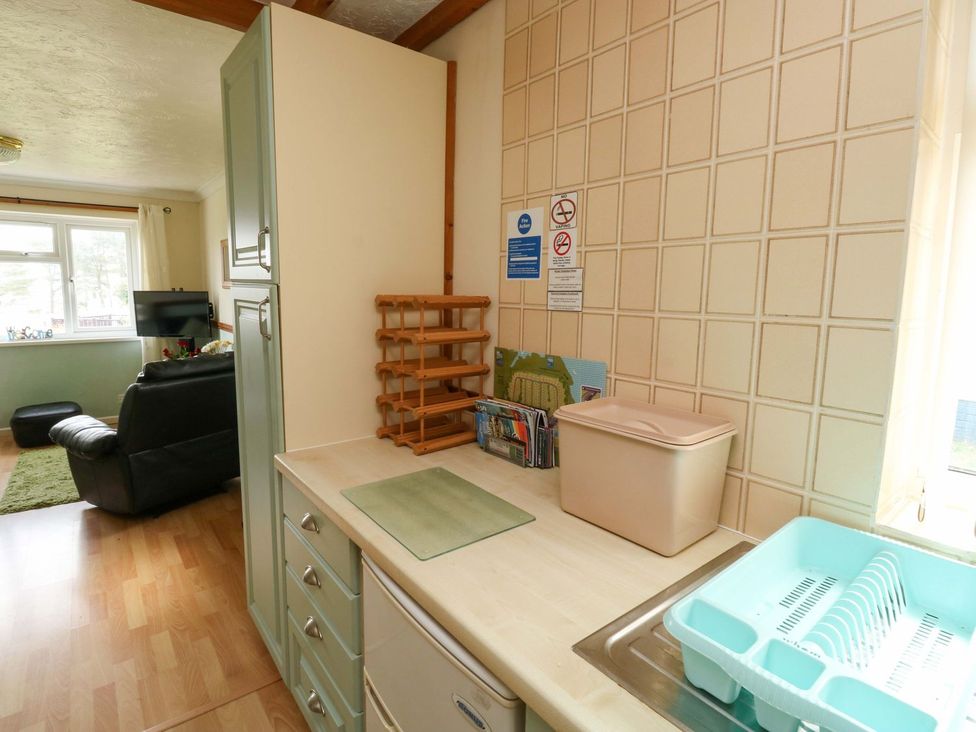 A kitchen with a sink and storage in Cottage 28 Brixham