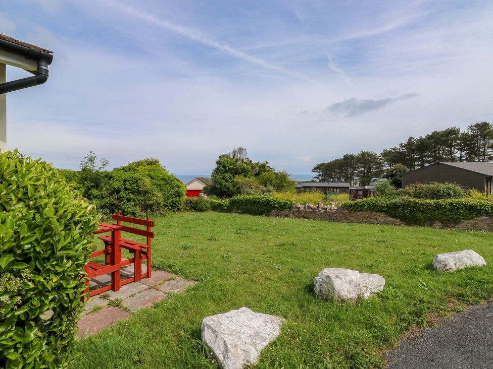 A garden with a bench and rocks at Cottage 28 in Brixham