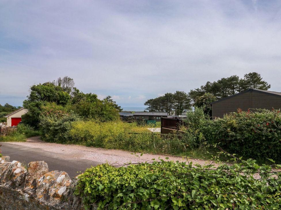 A view of a road with greenery and buildings at Cottage 28 in Brixham