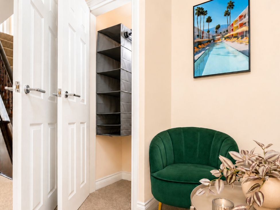 A hallway with a green chair and a shelf unit at 127 Columbus Ravine in Scarborough
