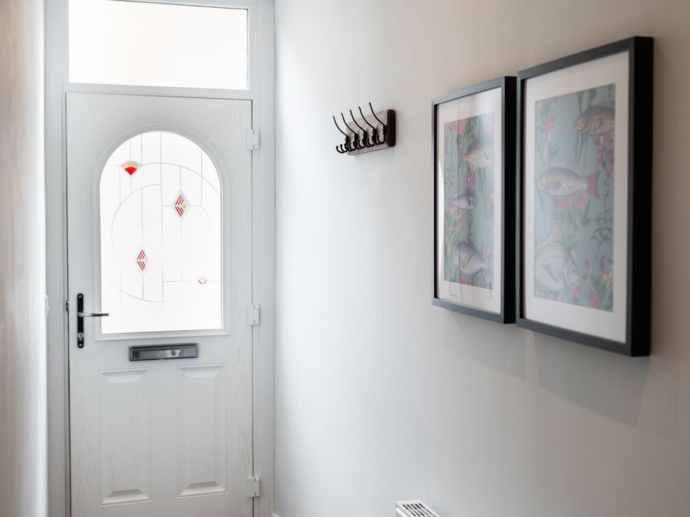 A hallway with a door and framed pictures at 23 Trafalgar Road in Scarborough