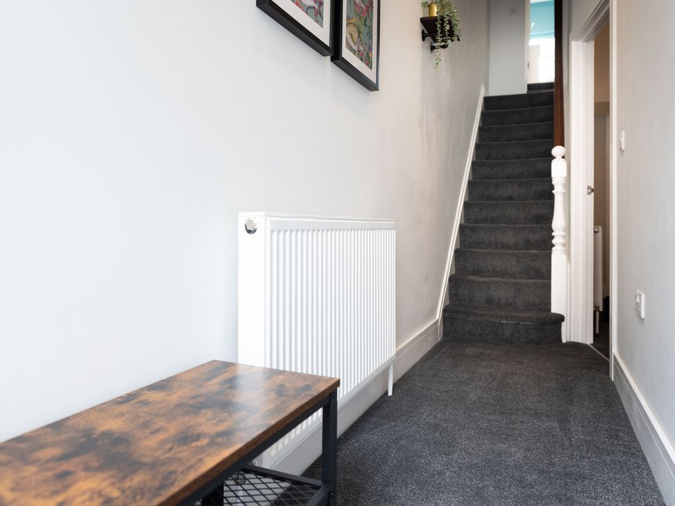 A hallway with a staircase and a radiator at 23 Trafalgar Road Scarborough