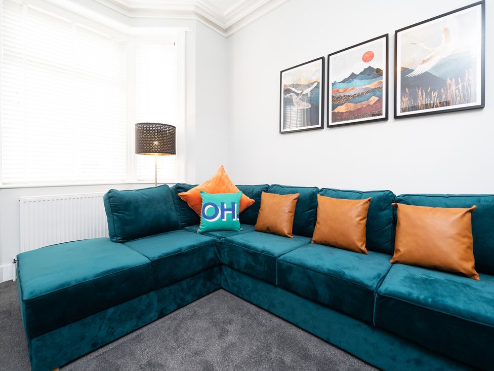 A living room with a corner sofa and artwork at 23 Trafalgar Road Scarborough