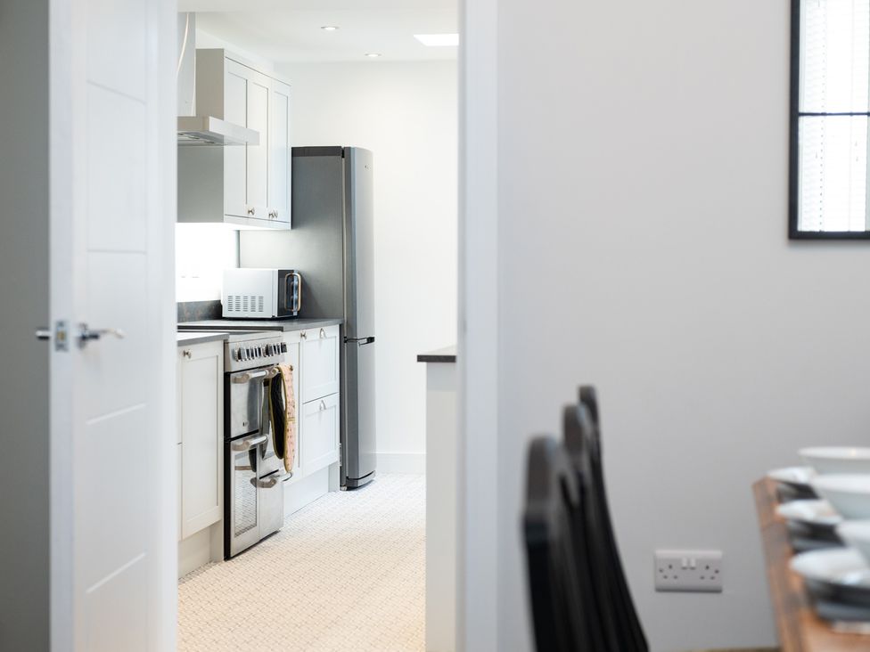 A kitchen with appliances and dining area at 23 Trafalgar Road in Scarborough