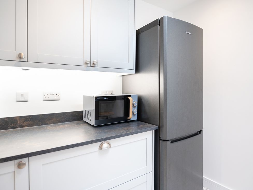 A kitchen with a microwave and refrigerator at 23 Trafalgar Road Scarborough