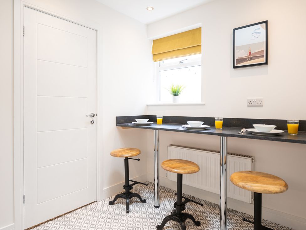 A kitchen with bar stools and a table at 23 Trafalgar Road in Scarborough