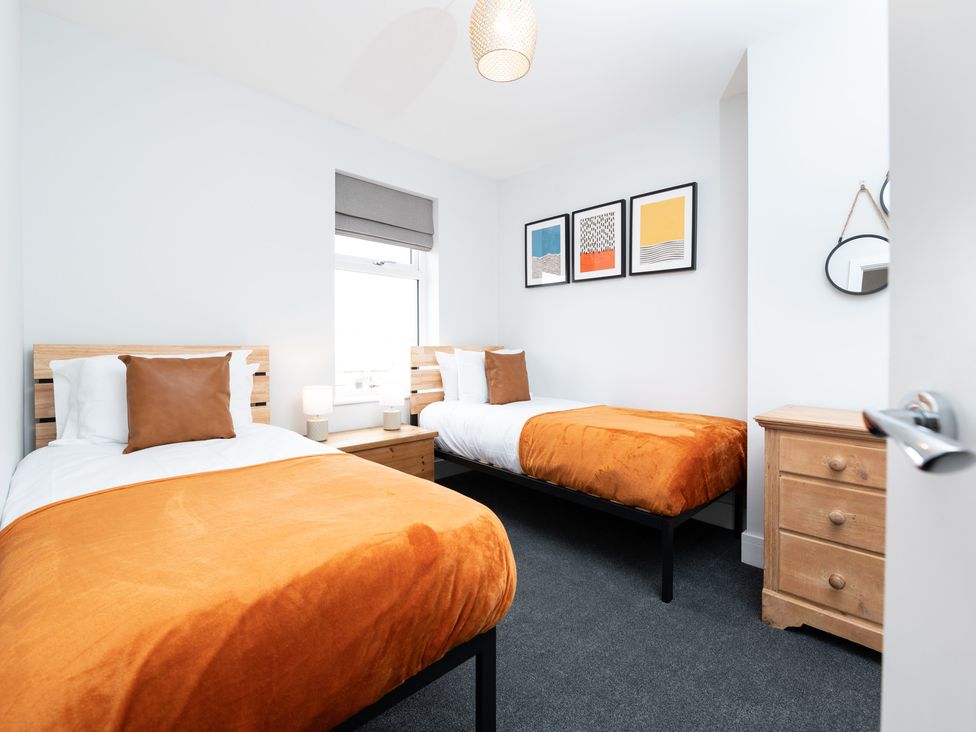 A bedroom with two single beds and artwork on the wall at 23 Trafalgar Road in Scarborough