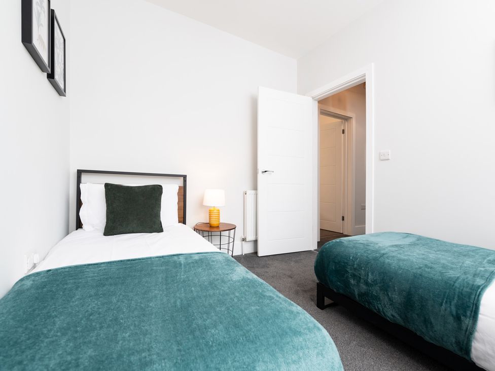A bedroom with two beds and a lamp at 23 Trafalgar Road in Scarborough