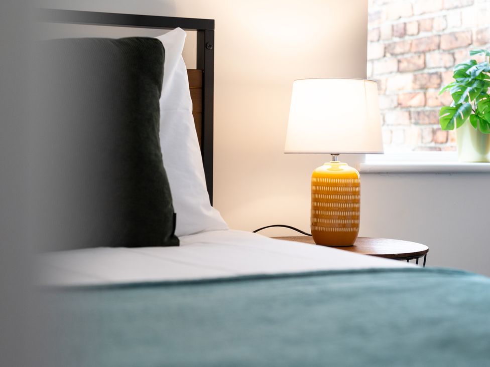 A bedroom with a bed and a lamp on a side table at 23 Trafalgar Road in Scarborough