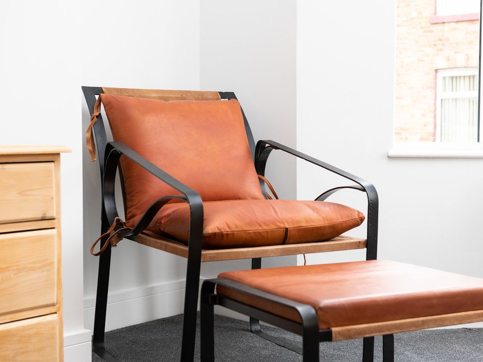 A chair and ottoman in a living room at 23 Trafalgar Road Scarborough
