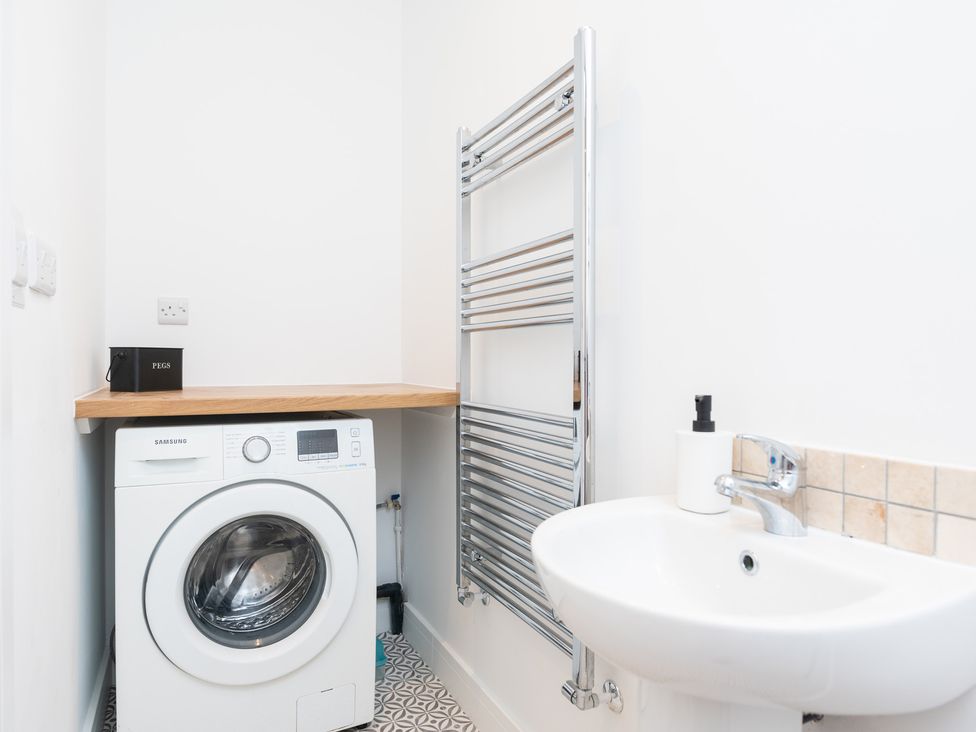A laundry room with a washing machine and sink at 23 Trafalgar Road Scarborough