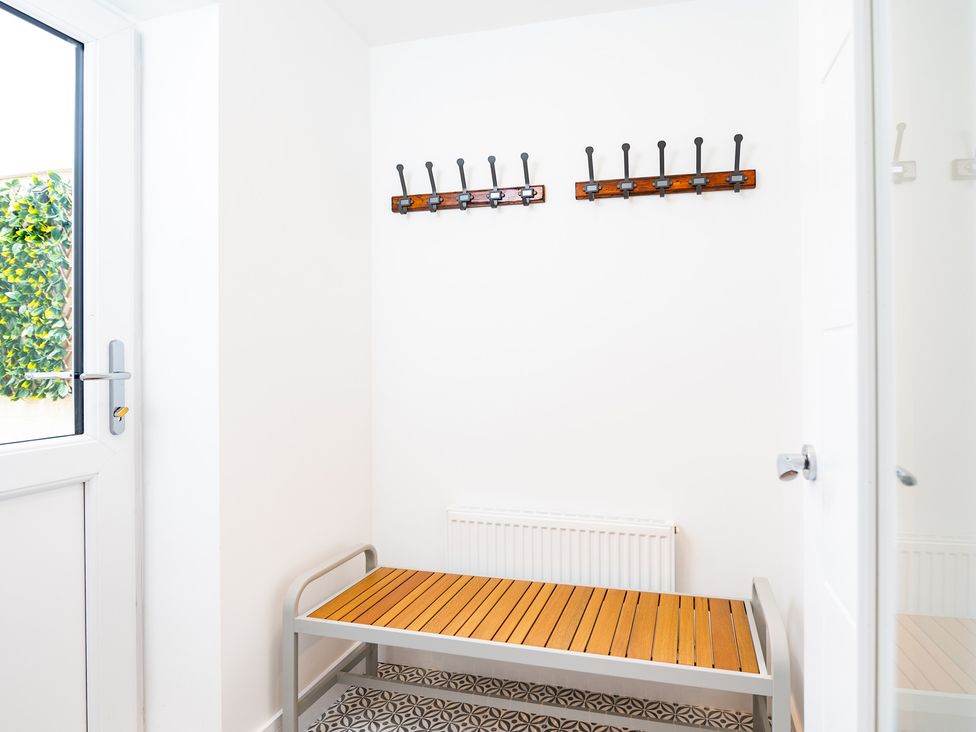 A hallway with a bench and coat hooks at 23 Trafalgar Road Scarborough