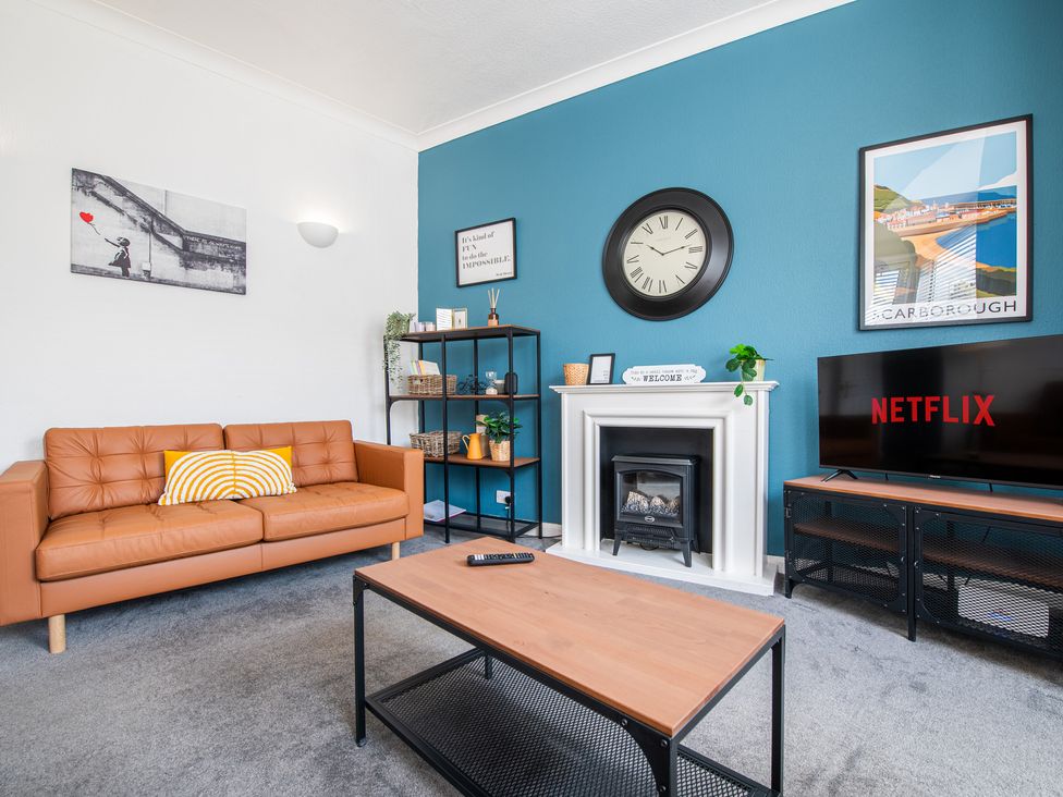 A living room with a sofa, coffee table, and television at 53A Hampton Road in Scarborough