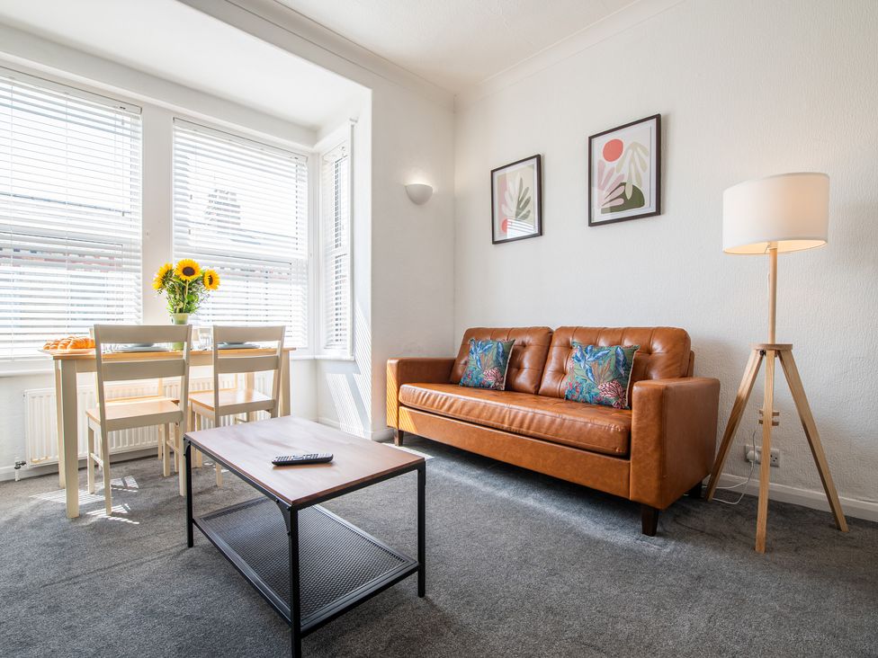 A living room with a sofa and dining table at 53A Hampton Road in Scarborough