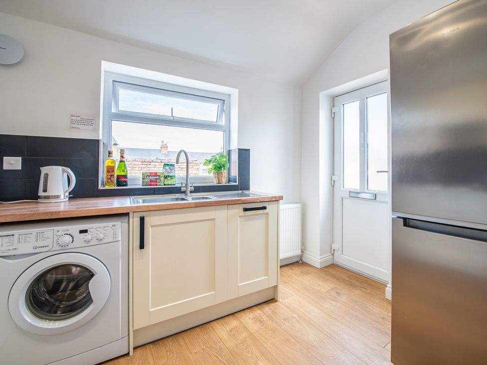 A kitchen with a sink and washing machine at 53A Hampton Road in Scarborough