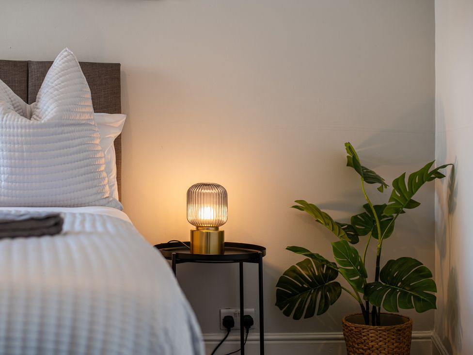 A bedroom with a bed, lamp, and plant at 53A Hampton Road Scarborough