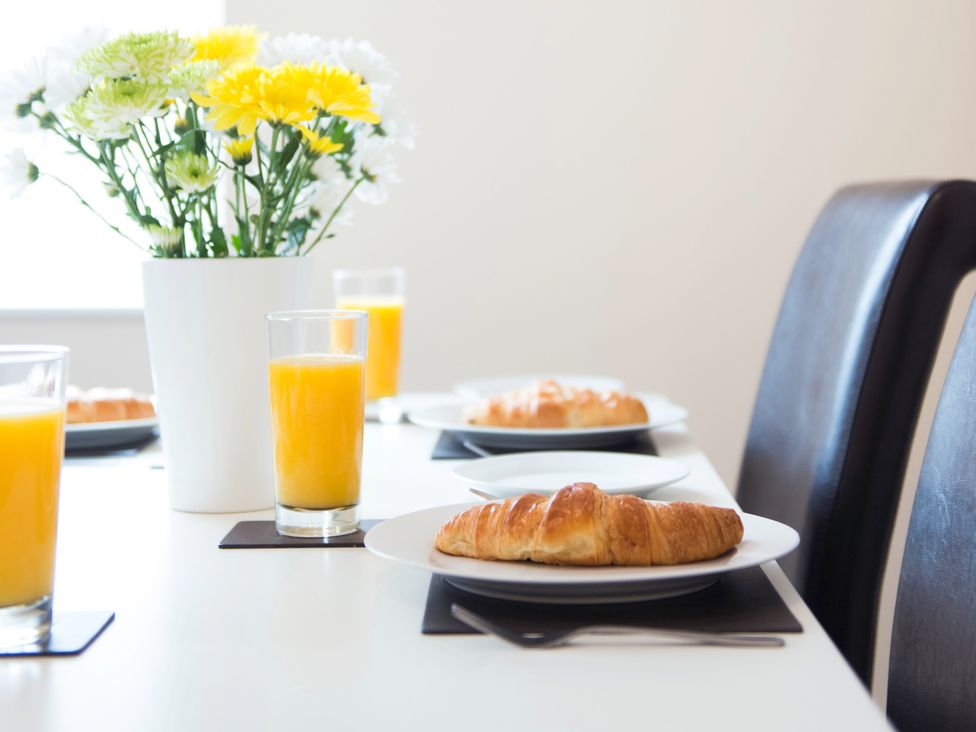 A dining table with flowers, orange juice, and croissants at 53 Hampton Road in Scarborough