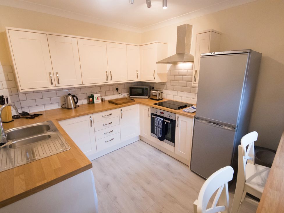 A kitchen with a stove and refrigerator at 53 Hampton Road Scarborough