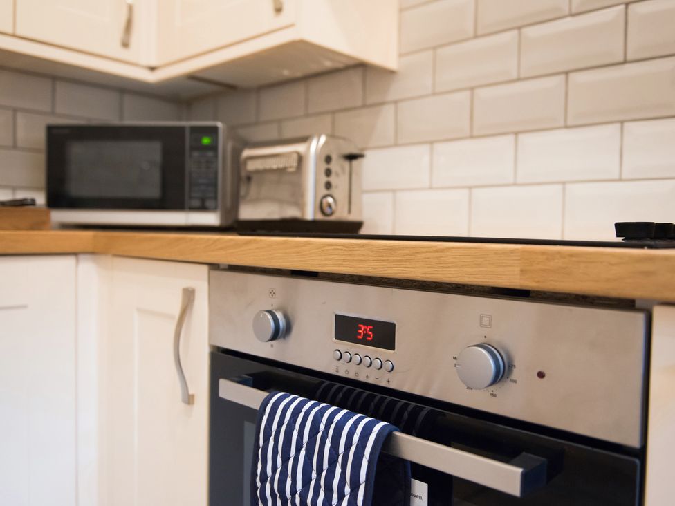 A kitchen with an oven, microwave, and toaster at 53 Hampton Road, Scarborough