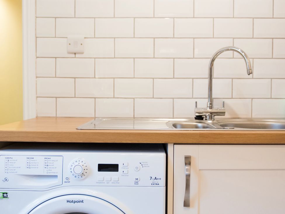 A kitchen with a washing machine and a sink at 53 Hampton Road Scarborough