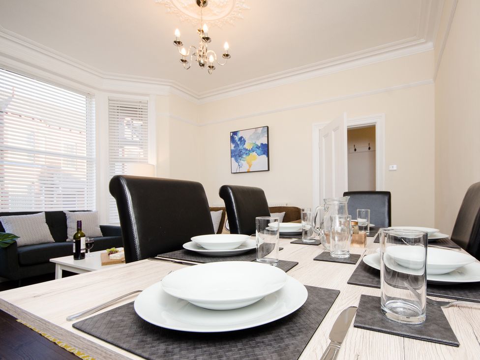 A dining room with a table set for meals at 46 Ashville Avenue, Scarborough