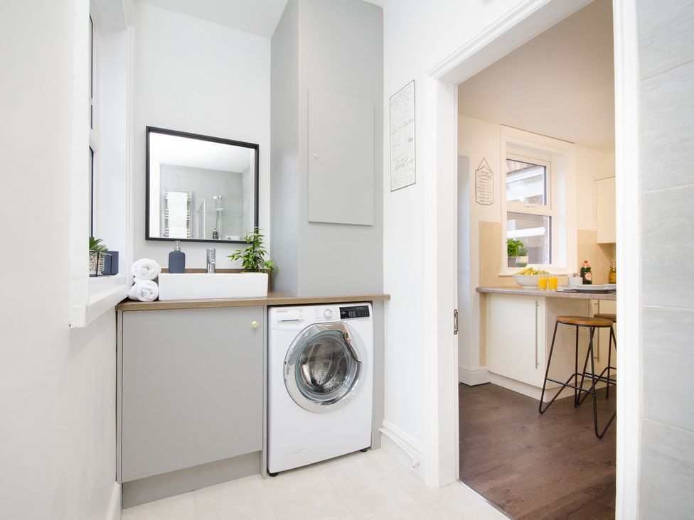A laundry room with a washing machine and mirror at 46 Ashville Avenue in Scarborough