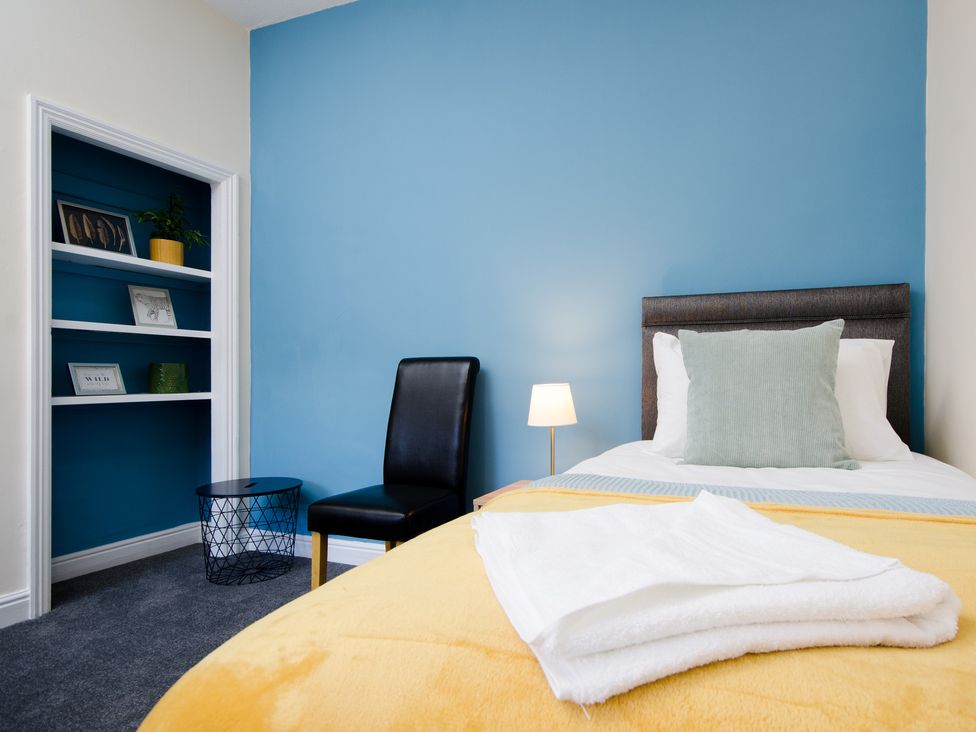 A bedroom with a bed and a chair at 46 Ashville Avenue in Scarborough