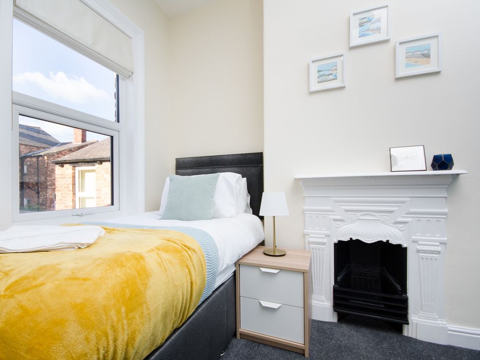 A bedroom with a single bed, side table and wall art at 46 Ashville Avenue in Scarborough