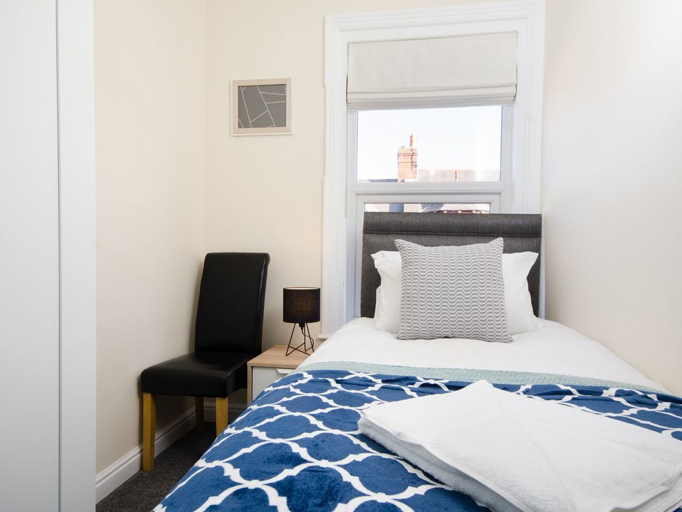 A bedroom with a bed and chair at 46 Ashville Avenue in Scarborough