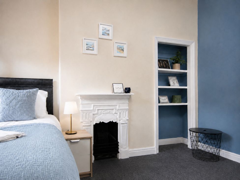 A bedroom with a bed, lamp, and bookshelf at 46 Ashville Avenue Scarborough
