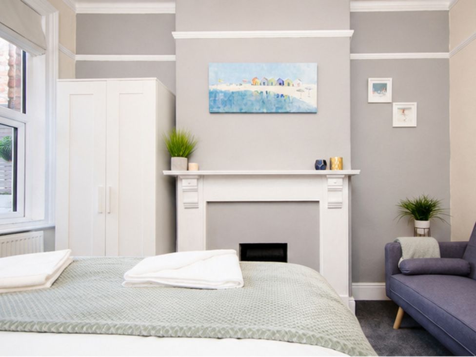 A bedroom with a bed, wardrobe, and fireplace at 46 Ashville Avenue, Scarborough