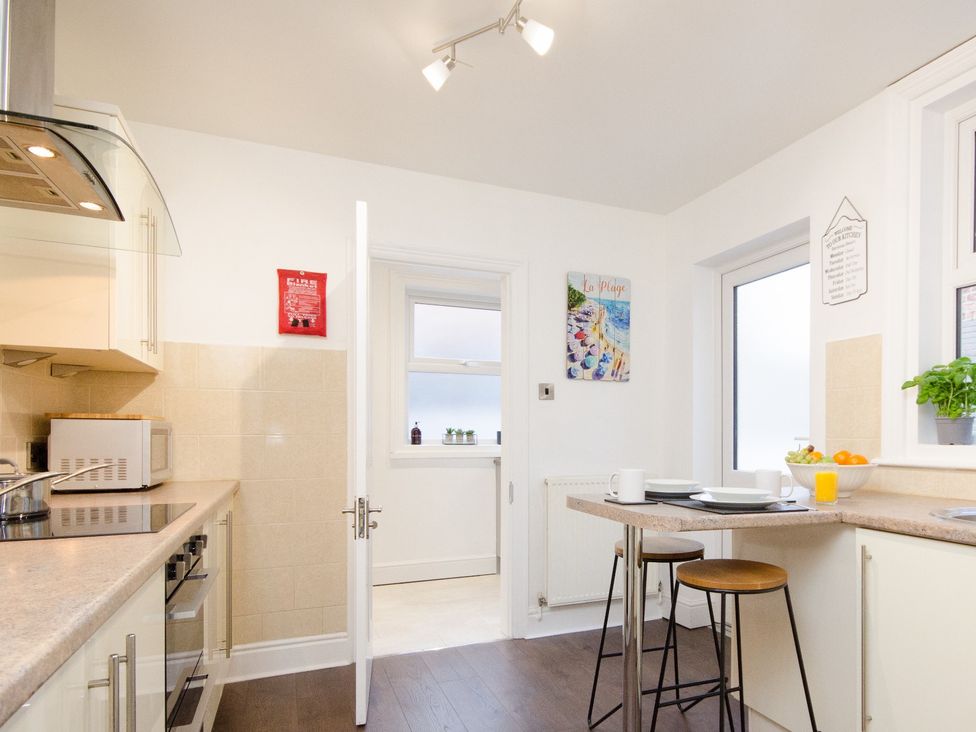 A kitchen with a countertop and bar stools at 46 Ashville Avenue in Scarborough