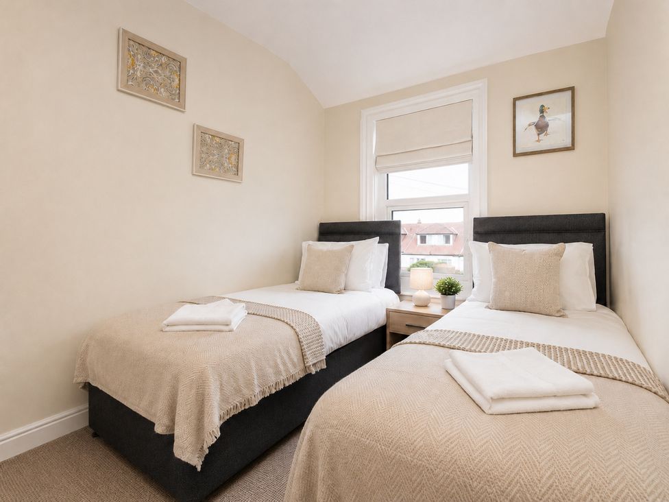 A bedroom with two single beds and a bedside table at 46 Ashville Avenue, Scarborough
