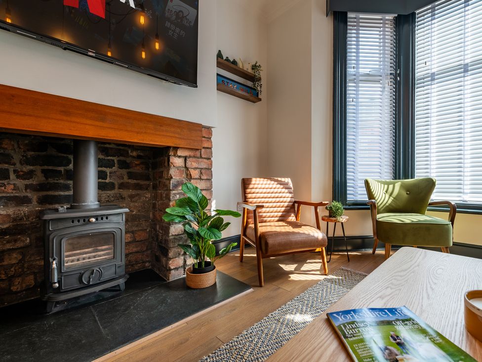 A living room with a fireplace and two armchairs at 22 Ashville Avenue, Scarborough
