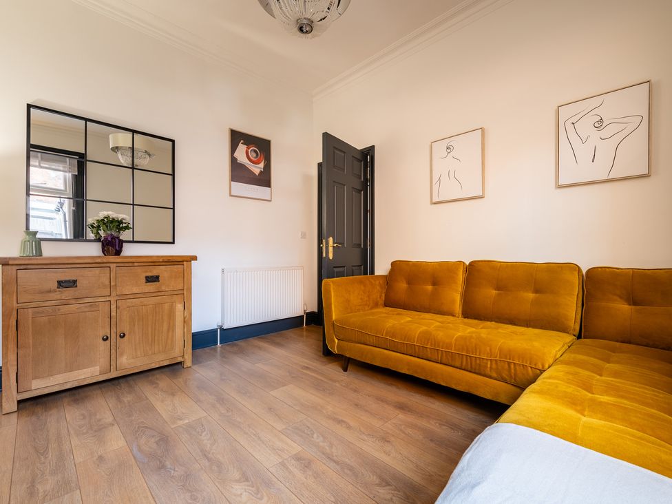 A living room with a sofa and mirror at 22 Ashville Avenue Scarborough