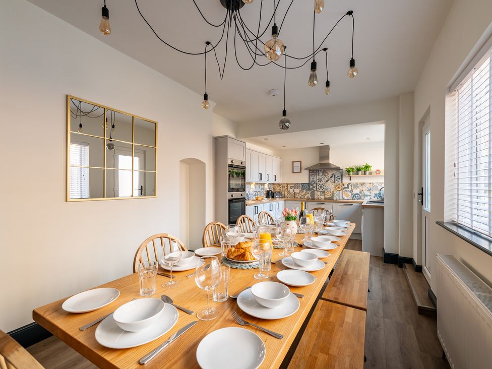 A dining room with a long table set for a meal at 22 Ashville Avenue in Scarborough