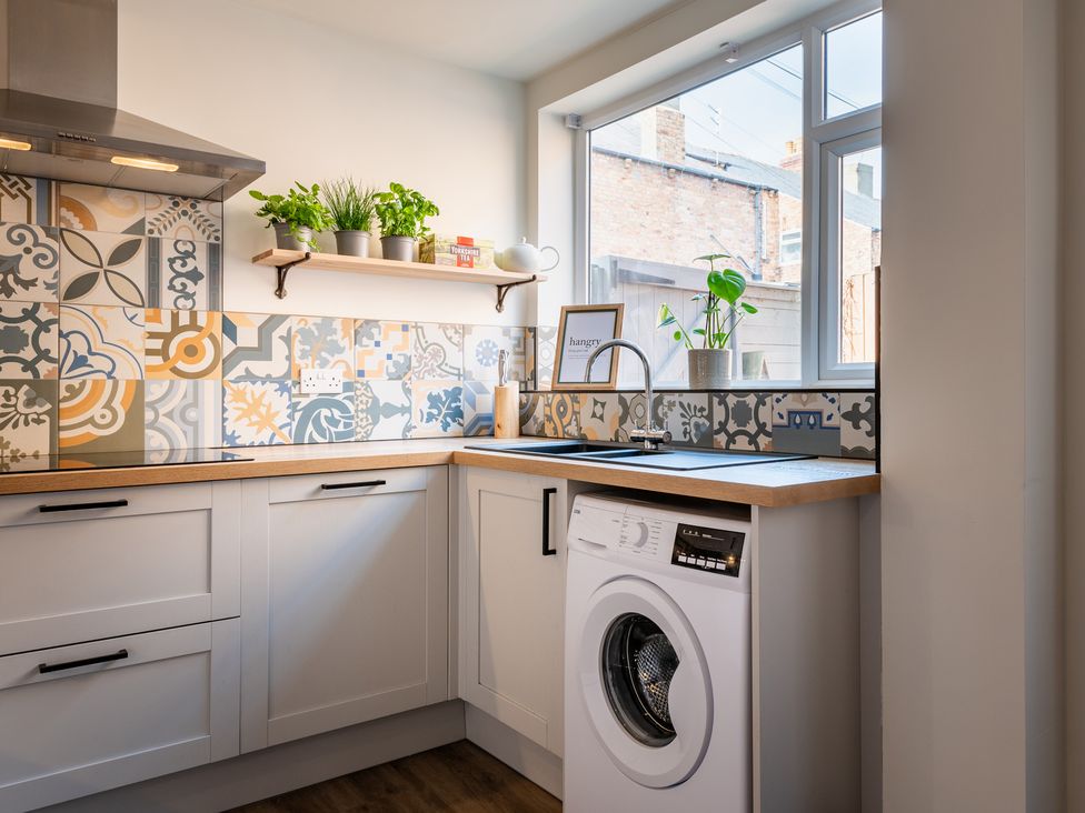 A kitchen featuring a washing machine and sink at 22 Ashville Avenue, Scarborough