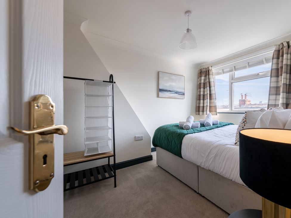A bedroom with a bed and a shelf unit at 22 Ashville Avenue in Scarborough