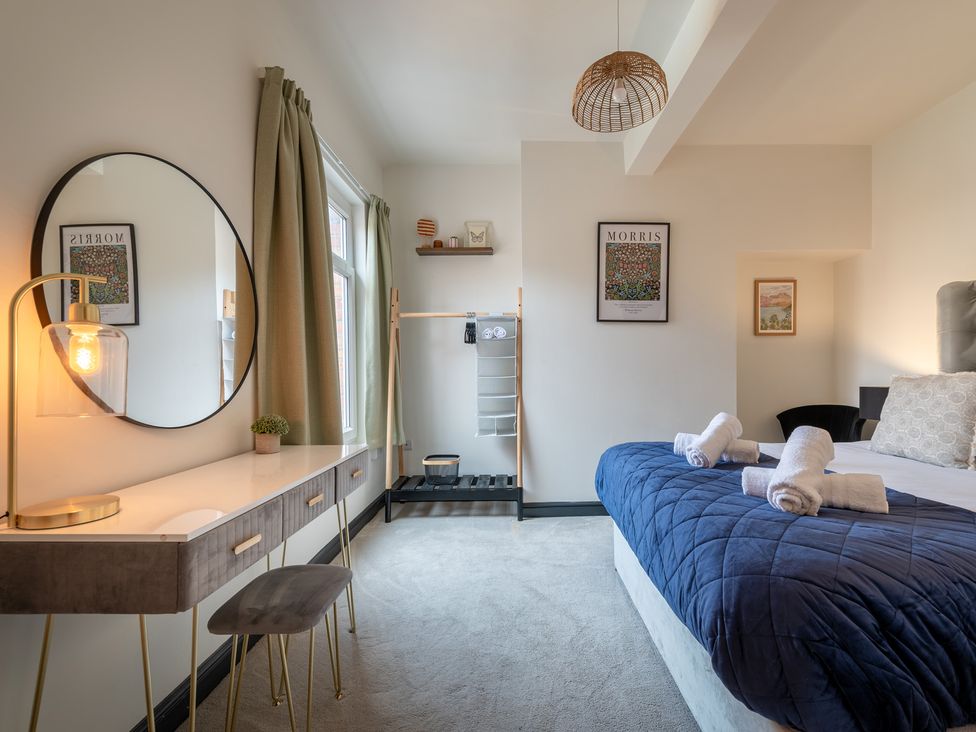 A bedroom with a bed, mirror, and clothes rack at 22 Ashville Avenue, Scarborough
